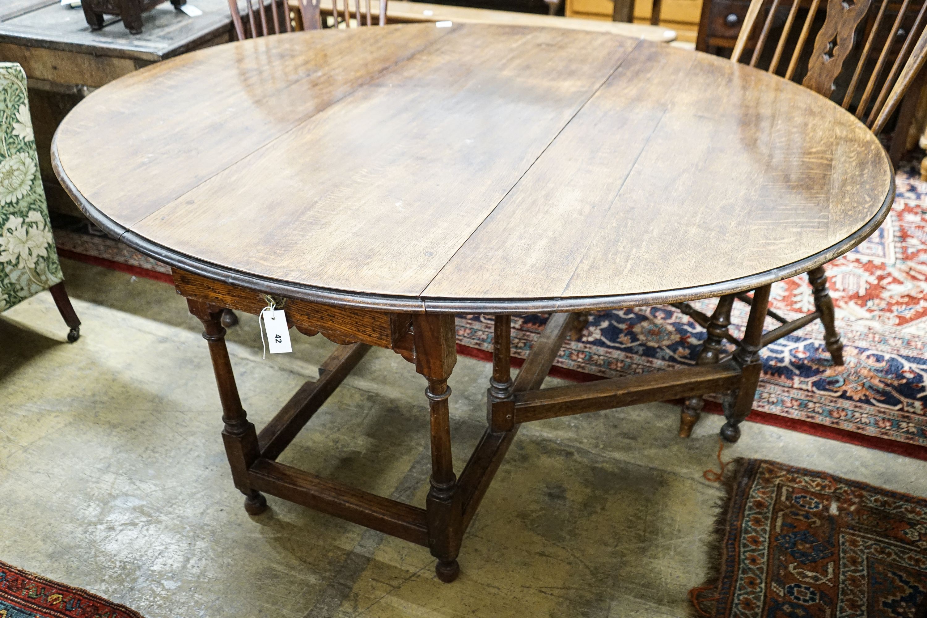 A 17th century style oak gateleg table, with oval top and two frieze drawers, open to 170cm, width 148cm, height 73cm